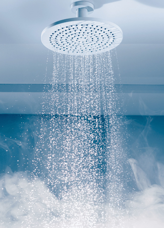 A round white rain shower head releasing a steady cascade of water.