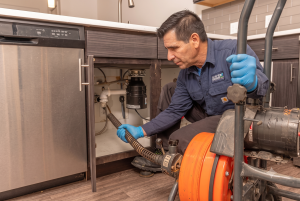 plumber checking underneath the sink