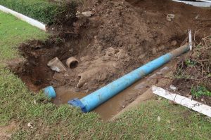 An excavated section of a lawn to access a sewer line.